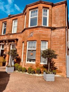 a large brick building with a clock on the front of it at Beechwood Ensuite Guest House in Ayr