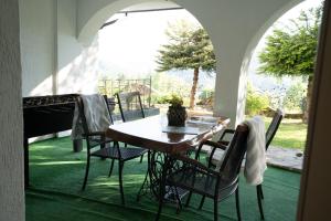 a table and chairs on a patio with a view of a yard at Noclegi Panorama in Ustrzyki Dolne