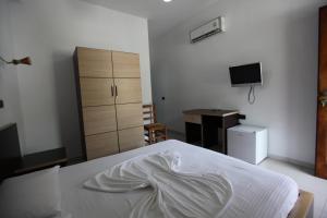 a bedroom with a bed with a dresser and a desk at Hotel Colosseo in Vlorë