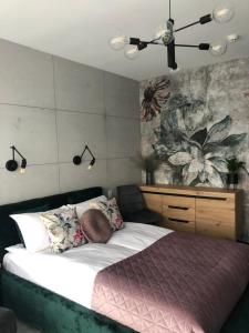 - une chambre avec un lit et une peinture murale dans l'établissement Apartament Lividus 210 ApartPark, à Świnoujście