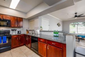 cocina con armarios de madera y encimera en Villa Captiva condo, en Scottsdale