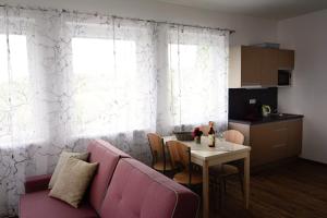 uma sala de estar com um sofá rosa e uma mesa em Apartmány Pemag Mikulov em Mikulov