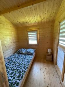 a wooden room with a bed in a log cabin at Domek nad Solina z klimatyzacją in Uherce Mineralne (7)
