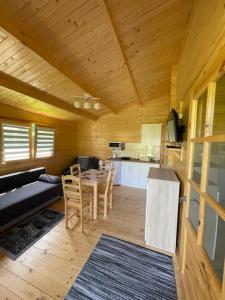 a living room with a table and a kitchen at Domek nad Solina z klimatyzacją in Uherce Mineralne (7)