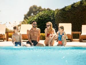 a group of people sitting in a swimming pool at St Raphael Resort in Limassol