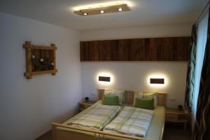 - une chambre avec un lit et des oreillers verts dans l'établissement Appartment Martina, à Fügenberg