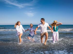 a group of people running on the beach at St Raphael Resort in Limassol