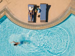 una vista panoramica di 2 persone in una piscina di St Raphael Resort a Limassol