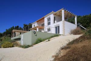 a white house on the beach with a driveway at Sunset Sea View Villa 5 in Arillas