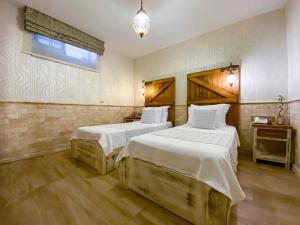 a hotel room with two beds and a window at PROVENCE MANSİON ALAÇATI in Alacati
