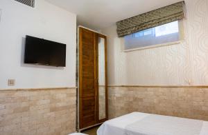 a bedroom with a bed and a television on the wall at PROVENCE MANSİON ALAÇATI in Alacati