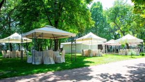 a group of tents with tables and chairs in the grass at Wing Club Hotel in Jagodina