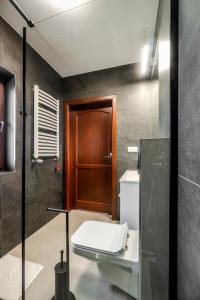 a bathroom with a toilet and a wooden door at Czeho House Domki Białka Tatrzańska in Białka Tatrzańska