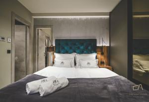 a bedroom with a large bed with a blue headboard at Galija Luxury Suites in Krk