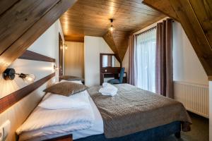 a bedroom with a large bed in a attic at Czeho House Domki Białka Tatrzańska in Białka Tatrzańska