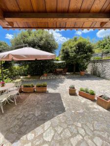 un patio con tavolo, ombrellone e piante di Casa Pacini a Santa Fiora