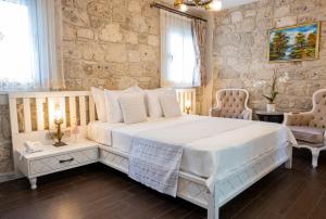 a bedroom with a large white bed and two chairs at PROVENCE MANSİON ALAÇATI in Alacati