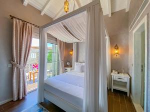 a bedroom with a canopy bed and a window at PROVENCE MANSİON ALAÇATI in Alacati