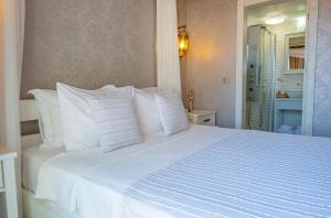 a white bed with white pillows in a bedroom at PROVENCE MANSİON ALAÇATI in Alacati