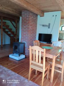 a dining room with a table and a stove at Staszkowa Zagroda nad Rospudą in Jabłońskie
