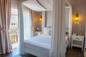 a bedroom with a canopy bed and a window at PROVENCE MANSİON ALAÇATI in Alacati +37 photos