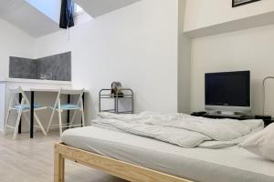Schlafzimmer mit einem Bett, einem TV und einem Schreibtisch in der Unterkunft Heart of Grenoble #BZ in Grenoble