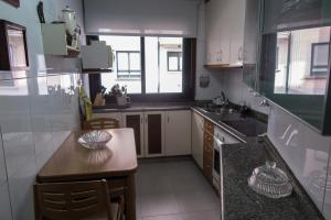 a kitchen with a counter and a table in it at GaliciaGuestHome Avenida Vigo 62 in Pontevedra