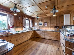 a large kitchen with wooden cabinets and wooden floors at Hotel Glockenstuhl in Westendorf