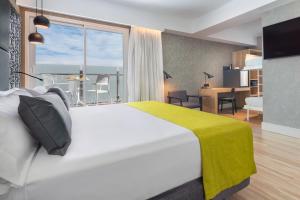pokój hotelowy z łóżkiem i dużym oknem w obiekcie Catalonia Giralda w Sewilli