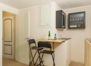 a kitchen with a bar with two chairs and wine glasses at Affittacamere Le Pescatrici in Riomaggiore +19 photos