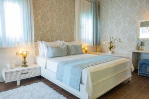 a bedroom with a large white bed and two windows at PROVENCE MANSİON ALAÇATI in Alacati