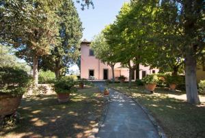 um jardim com árvores e uma casa rosa em Villa privata con piscina firenze chianti em Bagno a Ripoli