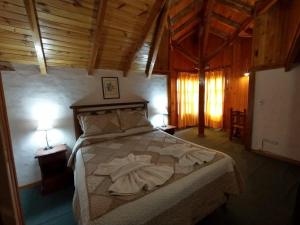 1 dormitorio con 1 cama grande y toallas. en Apart Manantial del Valle en San Martín de los Andes