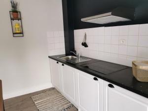 a kitchen with white cabinets and a sink at Duplex INDEPENDANT Centre ville in Les Herbiers