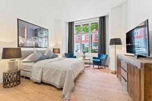 ベルリンにあるThe Weichsel - Group Flat in Central Berlin, Family-Friendly, 3BR, 2 bath rooms, 4- 6 Guestsのベッドと薄型テレビのある寝室
