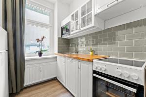ベルリンにあるThe Weichsel - Group Flat in Central Berlin, Family-Friendly, 3BR, 2 bath rooms, 4- 6 Guestsの白いキャビネット、シンク、窓付きのキッチン