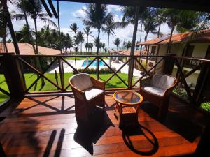 a balcony with chairs and a table and a pool at Casa Mia Pousada in Cabedelo