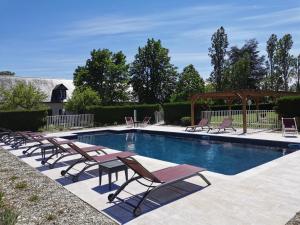 a swimming pool with lounge chairs and a gazebo at Logis Le Fleuray in Cangey