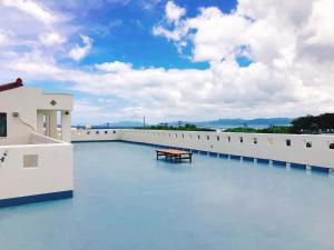 a bench on the roof of a building with water at Joya in Ishigaki Island