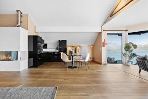 a kitchen and dining room with a view of the ocean at Utsikten in Kalvåg