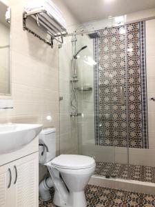 a bathroom with a shower and a toilet and a sink at Sabrina Hotel in Samarkand