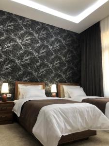 um quarto com 2 camas e uma parede preta em Sabrina Hotel em Samarkand