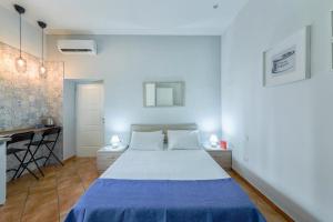een witte slaapkamer met een bed en een bureau bij Masaniello Apartment in Napels