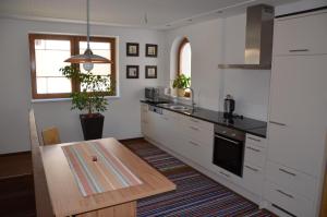 ヴァルト・イム・ピンツガウにあるAppartement Nischlerの白いキャビネットと木製テーブル付きのキッチン