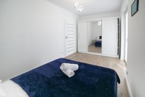 een slaapkamer met een blauw bed en een spiegel bij Oxygen apartament nr 1 in Mielec