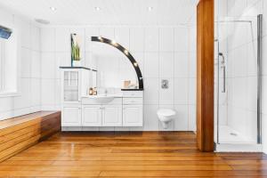 a white bathroom with a sink and a shower at Utsikten in Kalvåg