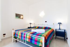 a bedroom with a colorful bed and two night stands at Villa Ciuri di fronte al mare in San Vito lo Capo