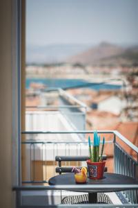 una mesa con una planta en la parte superior de un balcón en Porto Bello Nafplio, en Nauplia