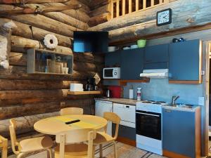 a kitchen with blue cabinets and a table and chairs at Rukanpovi RP 7 - Studio in Ruka