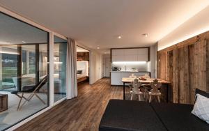 a living room and kitchen with a table and chairs at Bellevue Bruneck - Suites & Lofts in Brunico